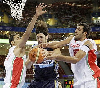 Argentina's Luis Scola, center, battles for a loose ball against Iran's Hamed Sohrabnejad, left, and Hamed Ehadadi, right